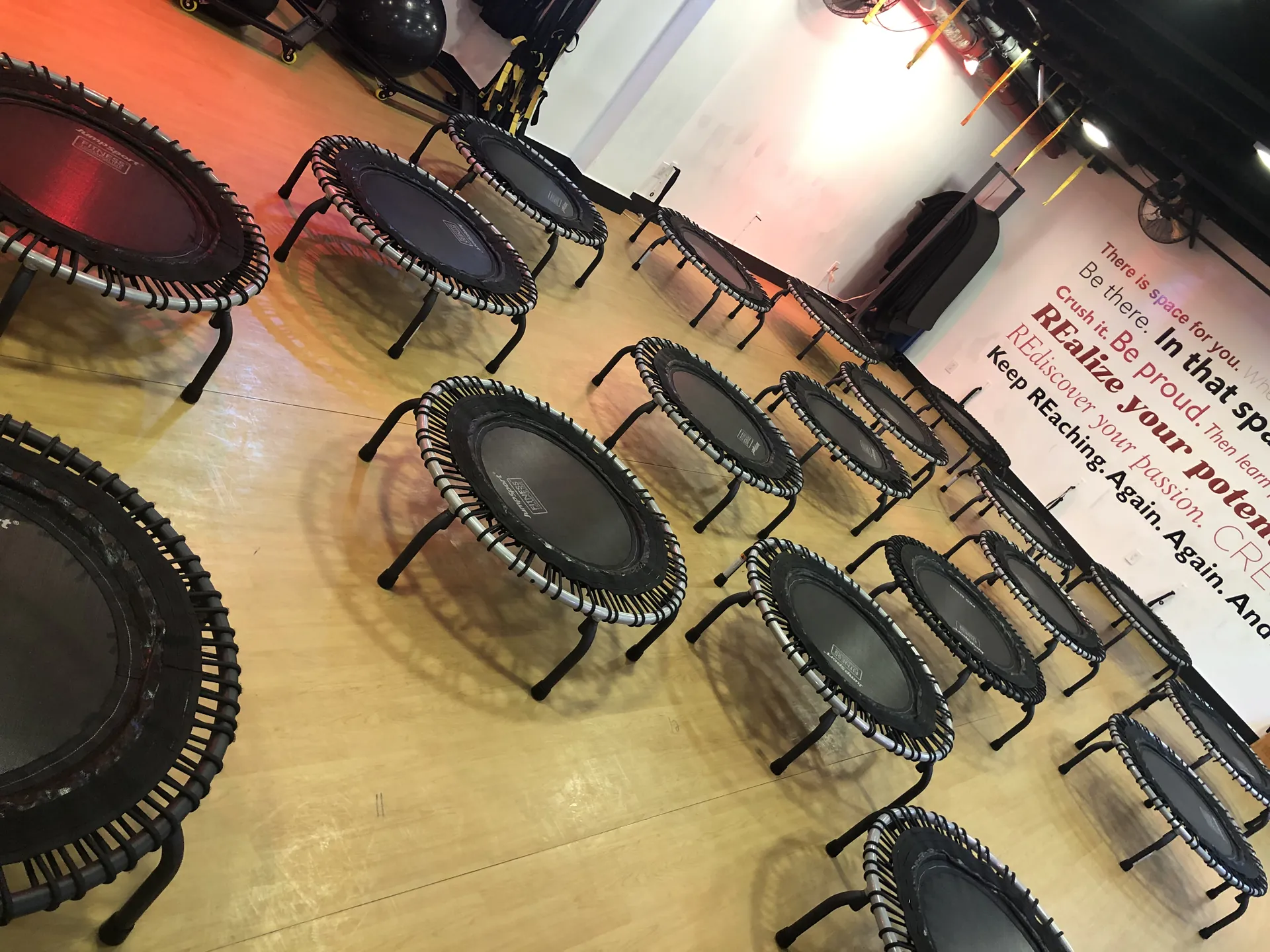 The Fitness Room floor filled with mini trampolines beneath the motivational wall mural