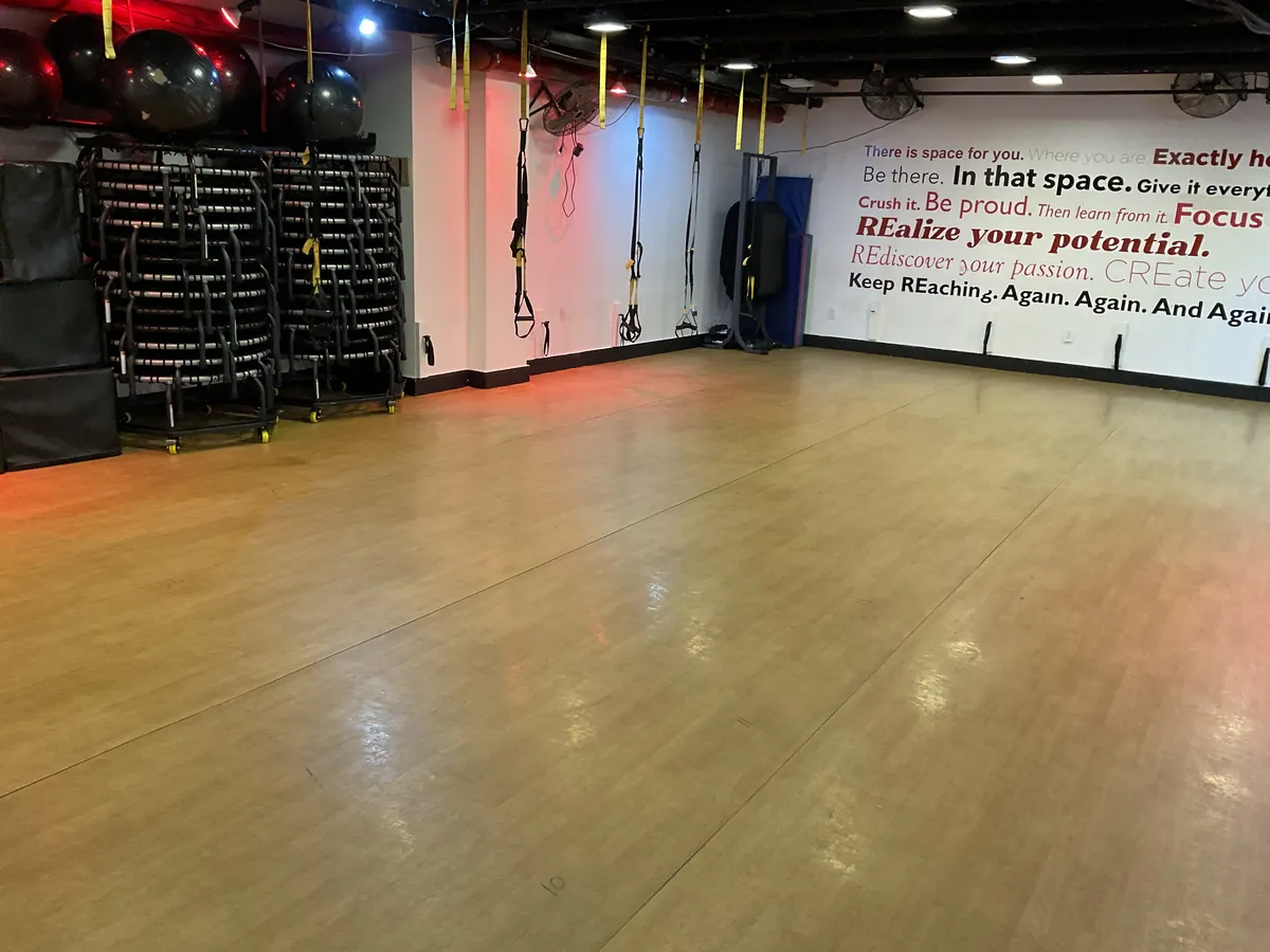 Fitness Room floor with equipment rack, motivational wall mural, and red accent lighting