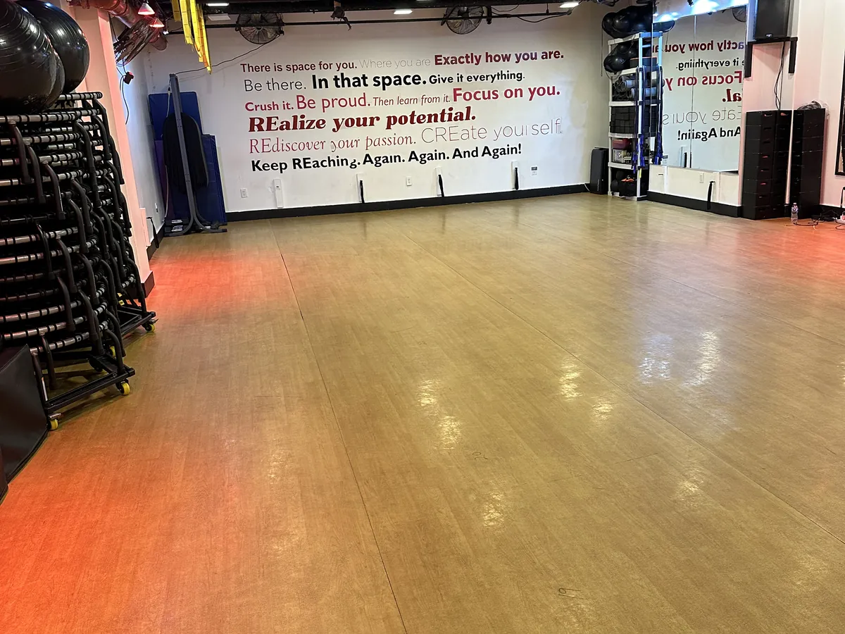 Open Fitness Room floor with motivational wall mural, ready for a stretch class