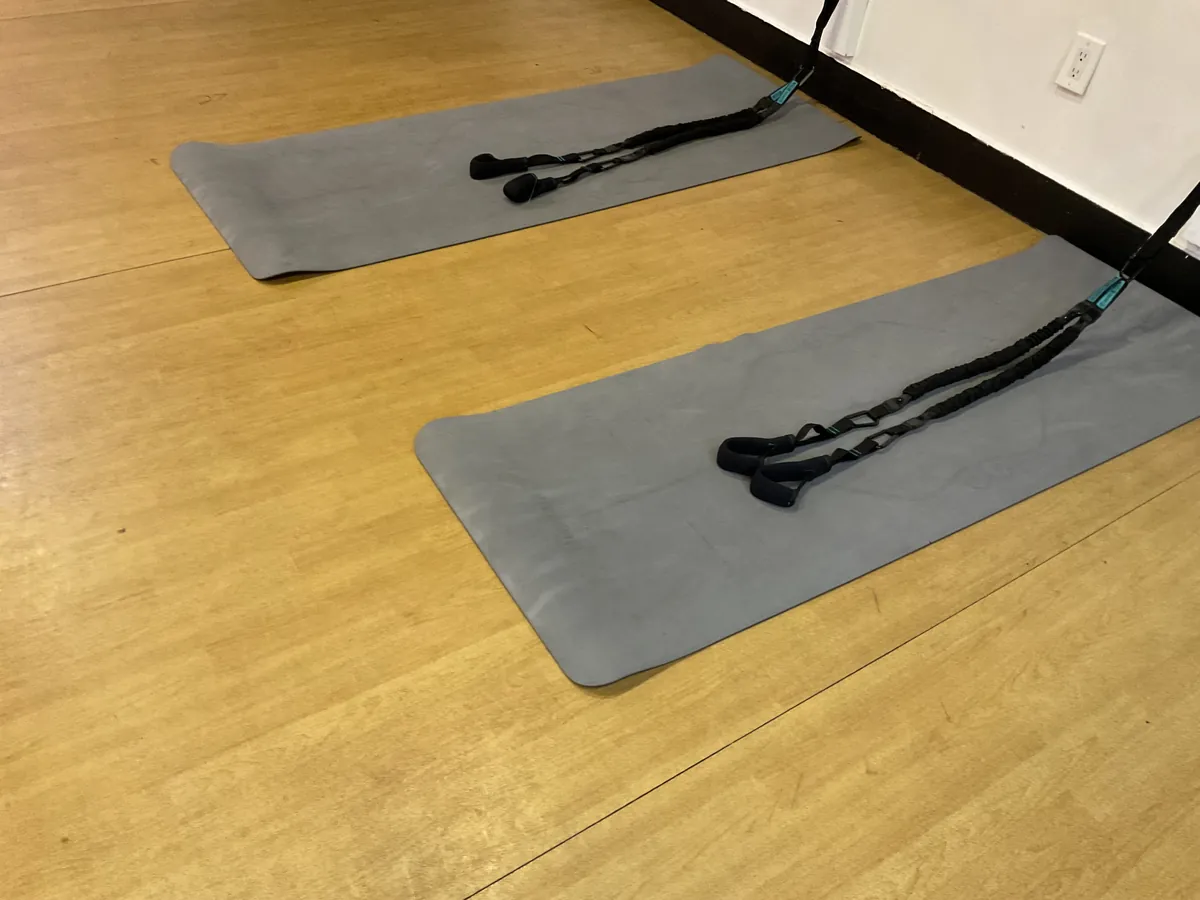 Mats laid out with wall-mounted band straps for Mat Pilates with Bands