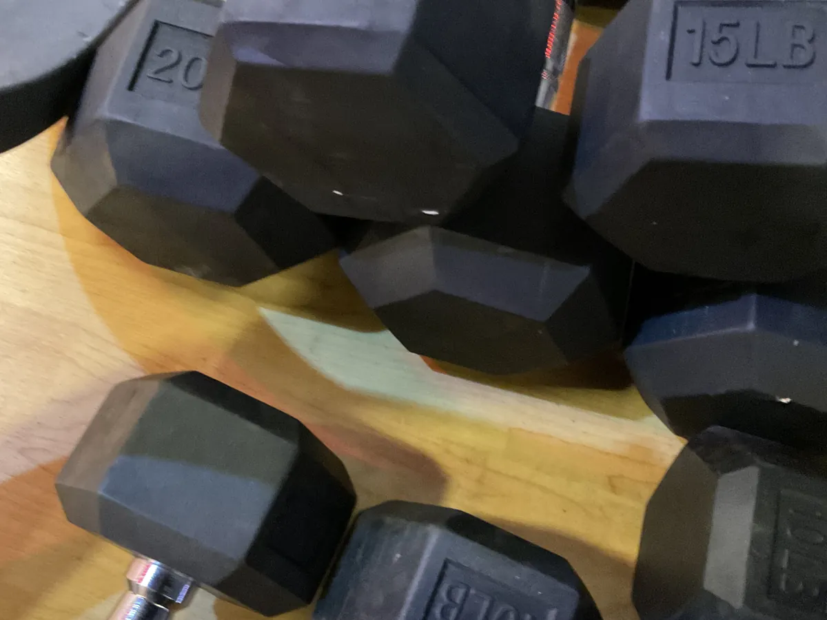 Rubber hex dumbbells gathered on the Fitness Room floor for REboot Mens