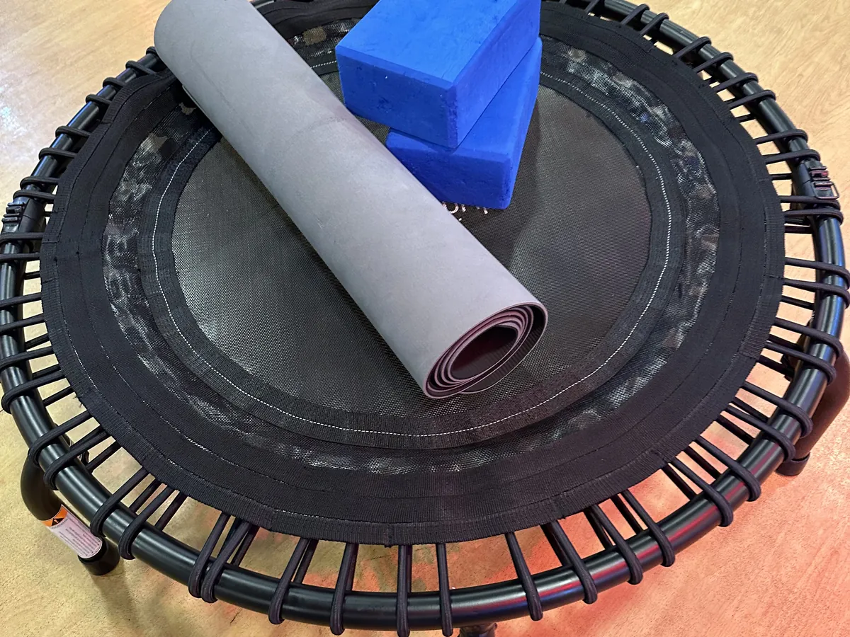 Rolled mat and yoga blocks on a mini trampoline for REbound + StREtch