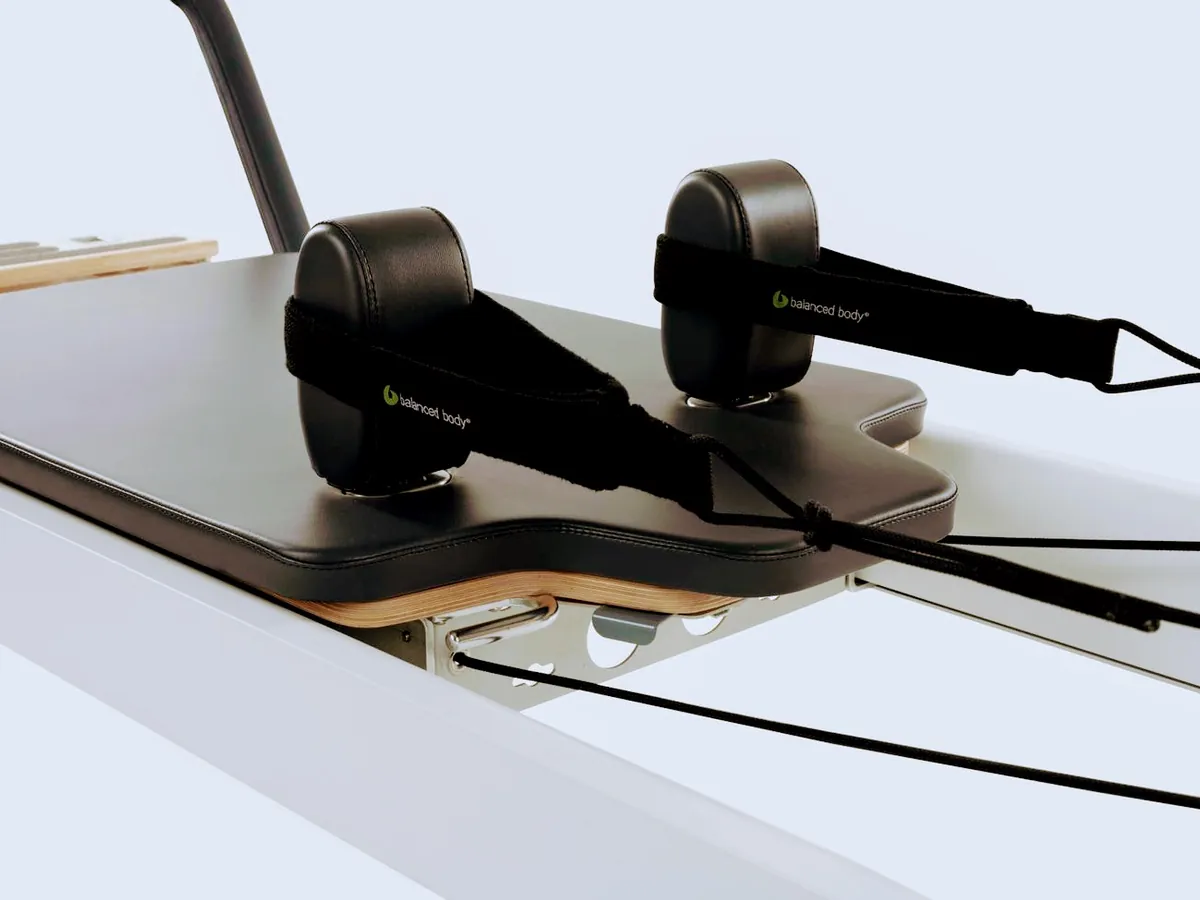 Close-up of a Pilates reformer carriage with straps for the advanced class