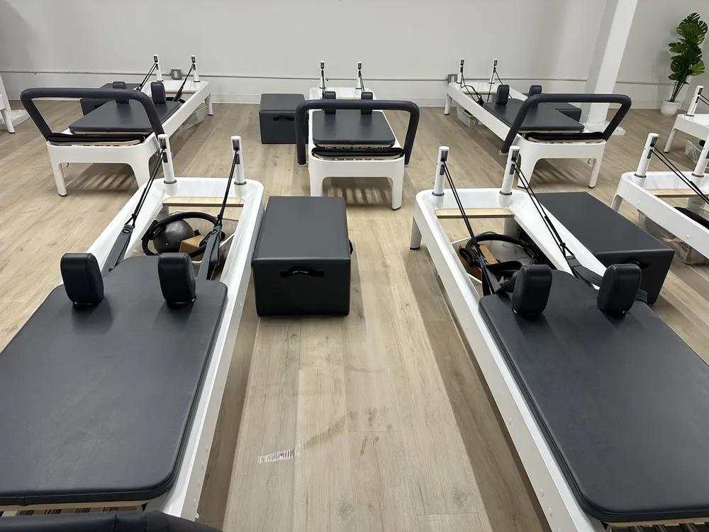 Rows of Pilates reformer beds lined up across the Reform Room studio floor
