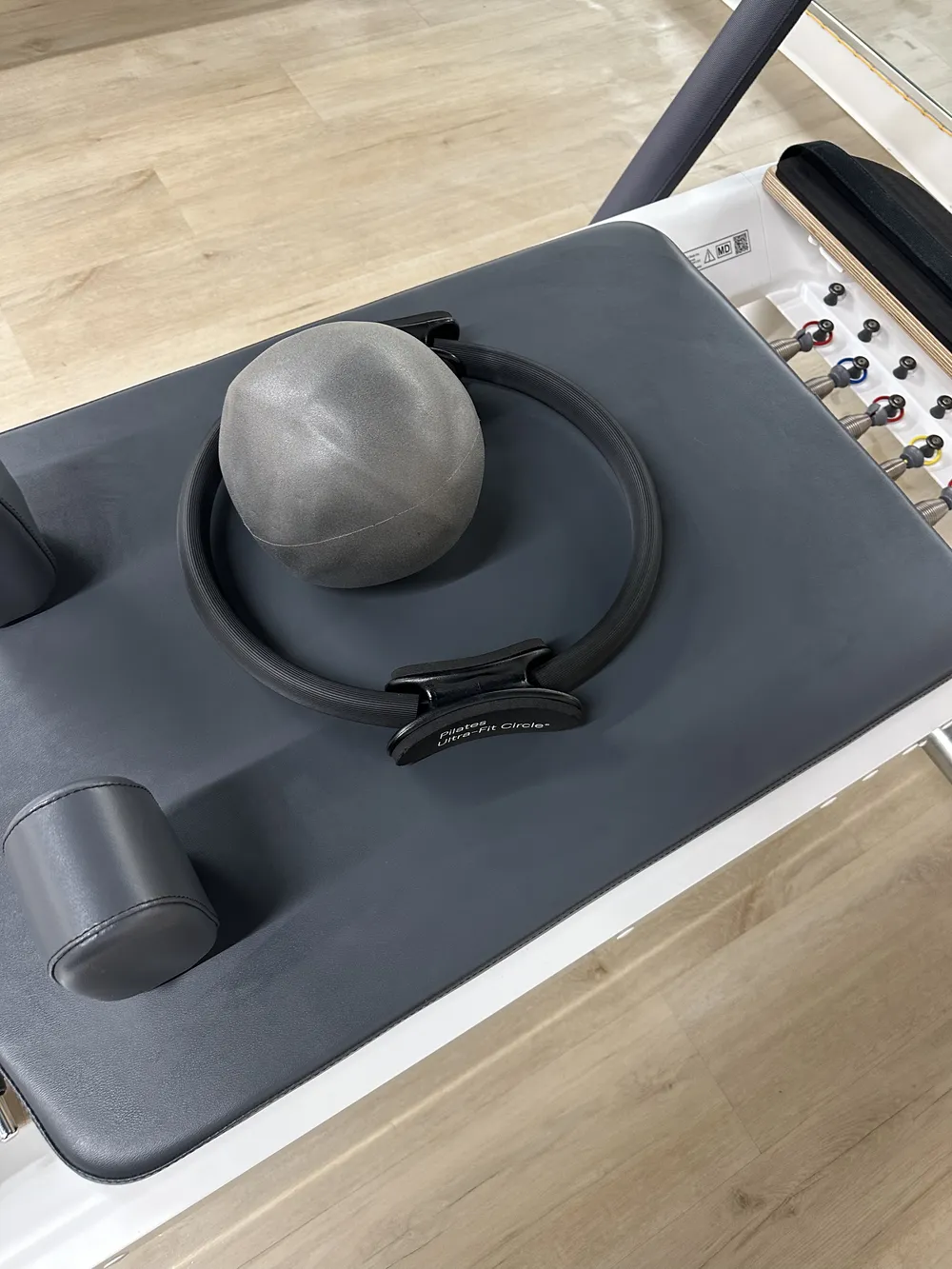 Reformer carriage close-up with a Pilates ball and magic circle resting on it